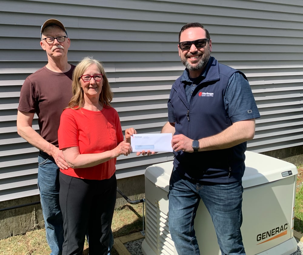 Prize-winning home owners in front of Generac whole home generator