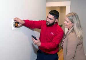 Showing a homeowner how to use a smart thermostat