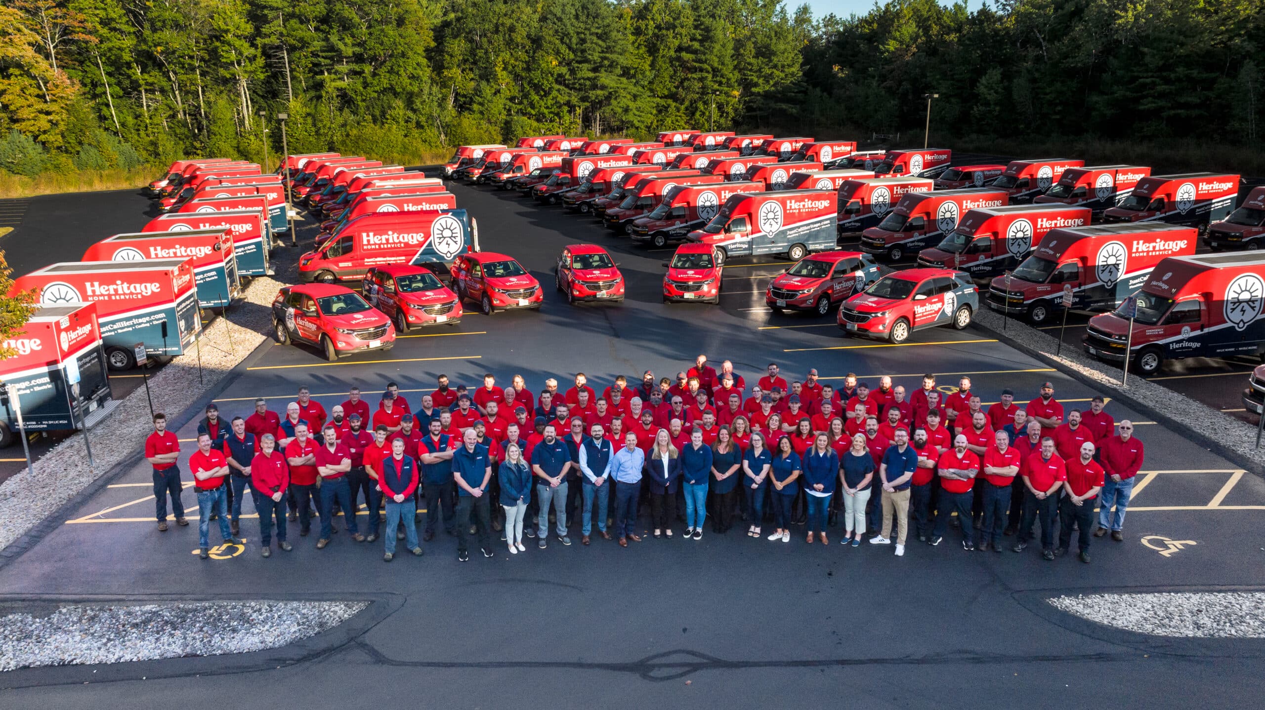 group photo of Heritage Home Service employees with service truck fleet