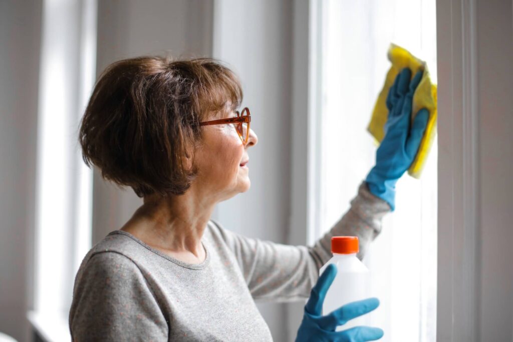 Older woman cleaning windows